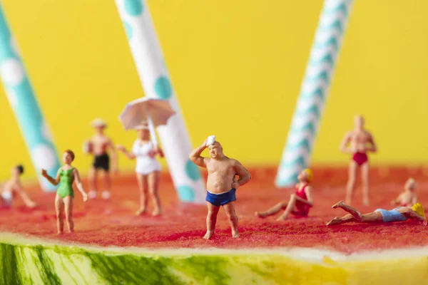 Pessoas em miniatura em maiô em uma melancia — Fotografia de Stock