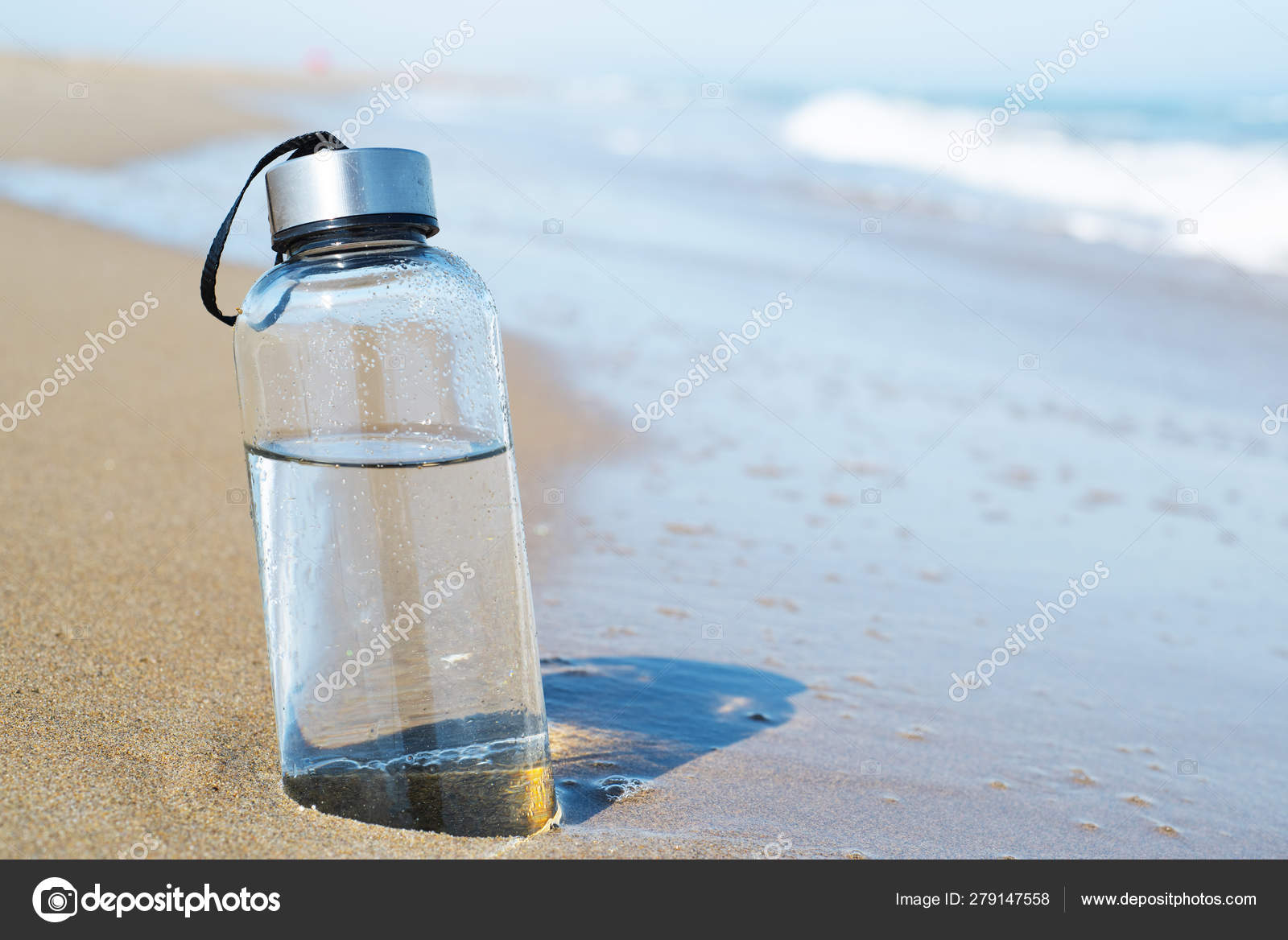 Reusable water bottle on the beach Stock Photo by ©nito103 279147558