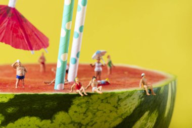 karpuz üzerinde mayo içinde minyatür insanlar