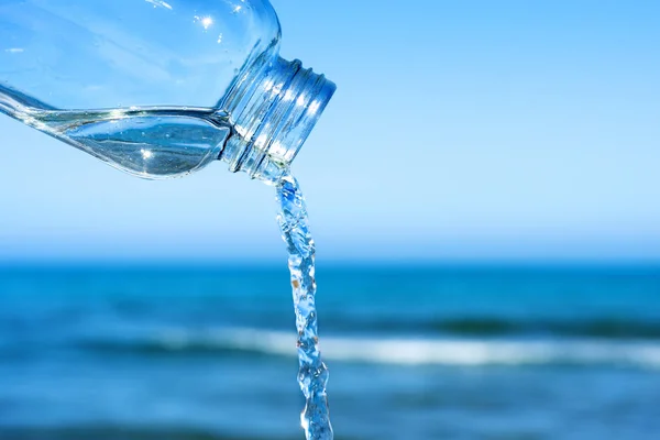 Eau sortant d'une bouteille réutilisable en verre — Photo