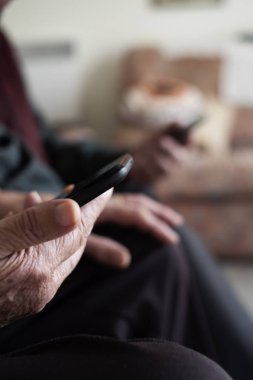 yaşlı kadın ve yaşlı adam onların akıllı telefonlar kullanarak