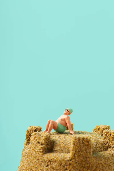 Miniature man in swimsuit on the beach — Stock Photo, Image