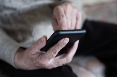 Akıllı telefon kullanan yaşlı kadın.