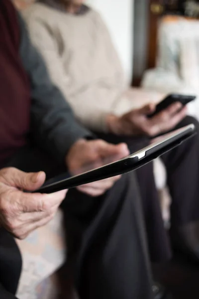 Anciana y anciano usando dispositivos electrónicos — Foto de Stock
