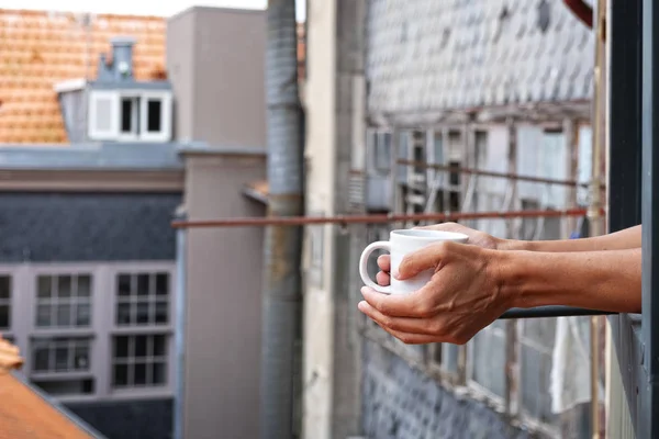 Ung man med en kopp kaffe på balkongen — Stockfoto