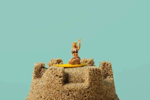 Миниатюрная женщина на песчаном замке — стоковое фото