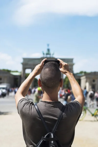 Jonge man die een foto neemt van het Brandenburg gat — Stockfoto