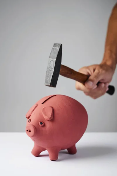 Man about to break a piggy bank with a hammer — Stock Photo, Image