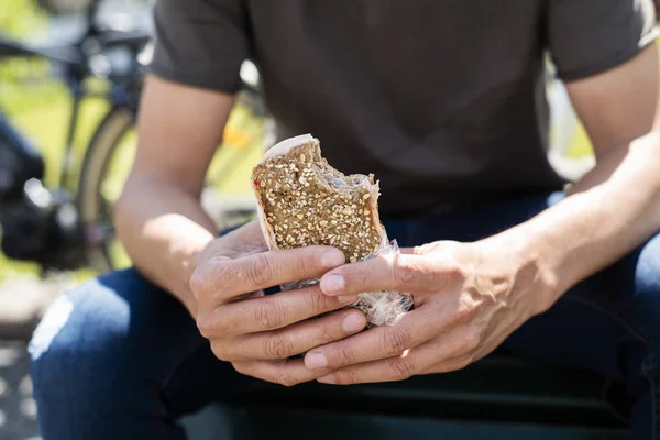 Άνθρωπος τρώγοντας ένα σάντουιτς γαλοπούλας σε εξωτερικούς χώρους — Φωτογραφία Αρχείου