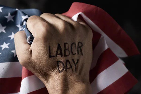 Poing levé, drapeau américain et texte journée du travail — Photo