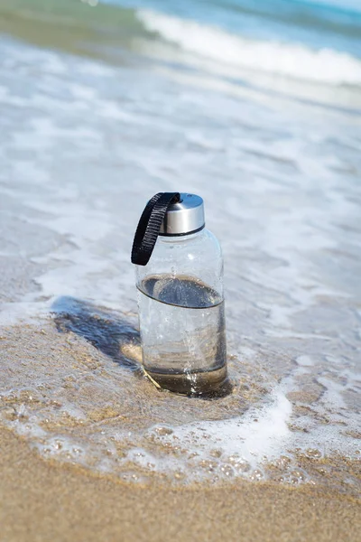 Багаторазова пляшка води на пляжі — стокове фото