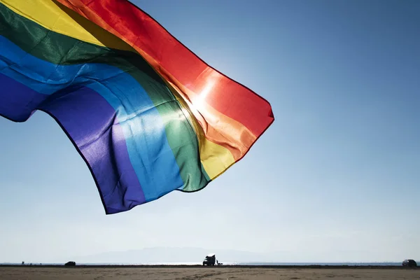 Bandera del arco iris ondeando en el cielo azul — Foto de Stock