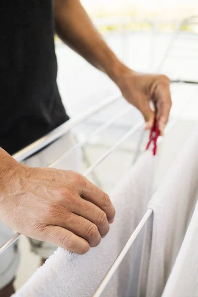 Мужчина вешает одежду на сушилку — стоковое фото