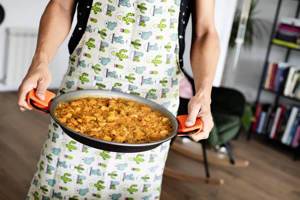 Homme avec une paella poulet espagnol — Photo