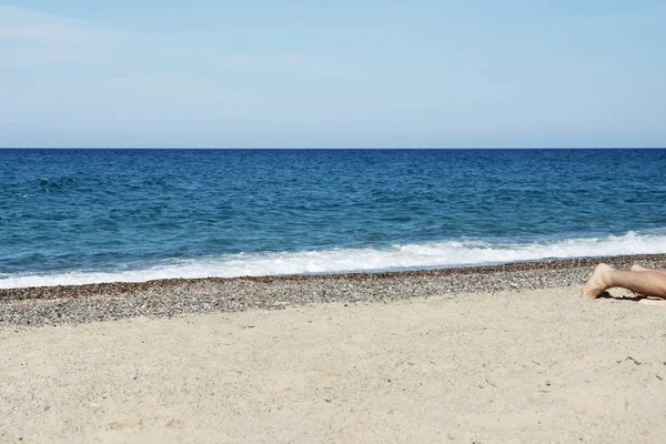 Człowiek leżący na plaży — Zdjęcie stockowe