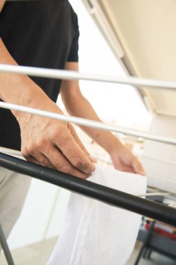 bir kurutma rac üzerinde giysi asılı adam