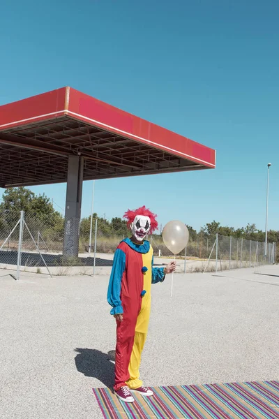 Payaso aterrador con un globo de oro al aire libre —  Fotos de Stock