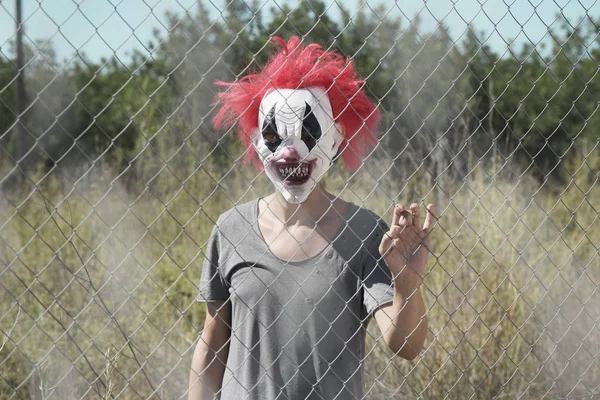 Scary clown bakom ett staket — Stockfoto