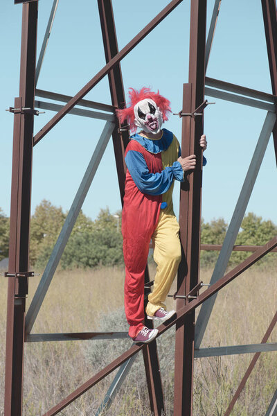 scary clown sticking out his tongue outdoors