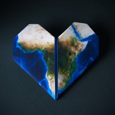Origami kalp, bir Afrika haritası (NASA tarafından döşenmiştir) ile desenli, koyu gri dokulu arka plan üzerinde