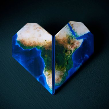 origami heart, patterned with a map of Africa (furnished by NASA), on a dark gray textured background clipart