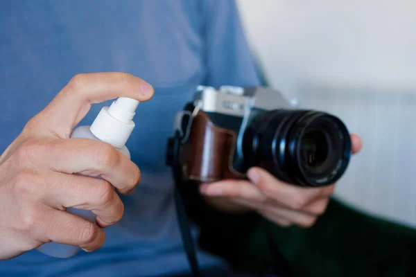 Närbild Kaukasisk Man Desinficera Sin Kamera Genom Att Spraya Desinfektionsmedel — Stockfoto