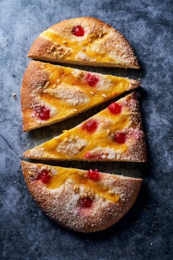 Katalonya, İspanya 'dan gelen tipik bir tatlı pasta olan Sant Joan kokaininin yüksek açılı görüntüsü, Aziz Johns arifesinde yenir, gri bir taş yüzeyde şekerle serpilmiştir.