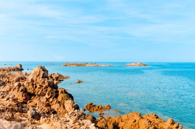 Fransa 'nın güney kıyısındaki La Tonnara' daki kaya oluşumlarının arka planda sakin Akdeniz manzarası