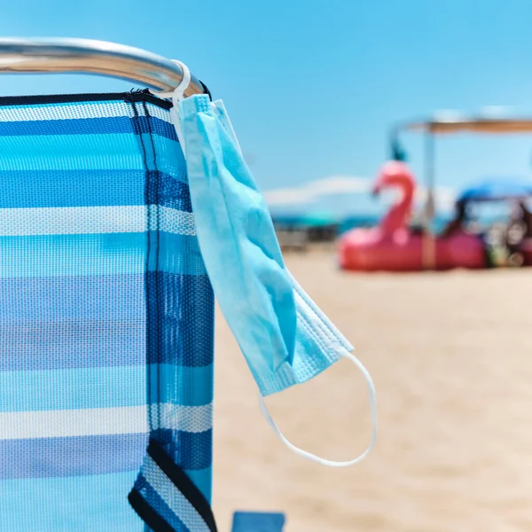 Närbild Kirurgisk Mask Hängande Blå Solstol Stranden Med Havet Bakgrunden — Stockfoto