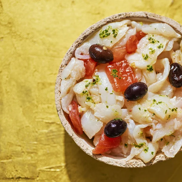 西班牙加泰罗尼亚特有的一种用鳕鱼 西红柿 洋葱和黑橄榄制成的冷盘子 上面用橄榄油装饰着金黄色的表面 — 图库照片