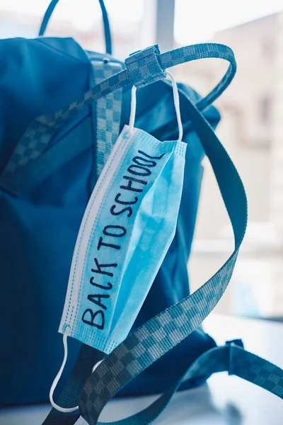 Fechamento Uma Bolsa Verde Uma Máscara Cirúrgica Azul Com Texto — Fotografia de Stock