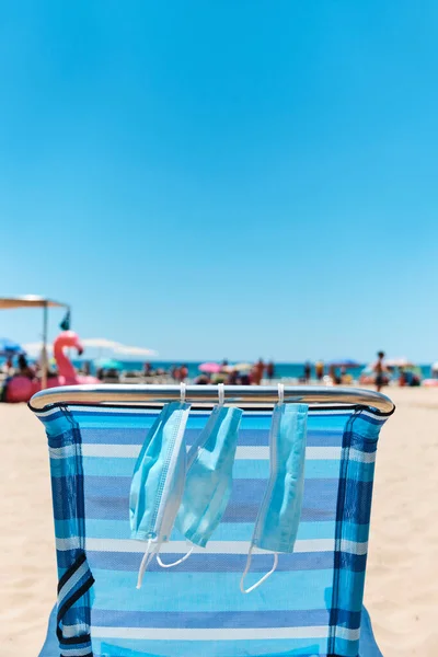 Some Surgical Masks Hanging Blue Deck Chair Beach Sea Background — Stock Photo, Image