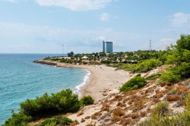 HOSPITALET DEL INFANT, İSPA - 28 AĞUSTOS 2020: Arka plandaki Vandellos II nükleer enerji santralini vurgulayan Hospital del Infant, İspanya 'daki Cala de Gestell plajının manzarası
