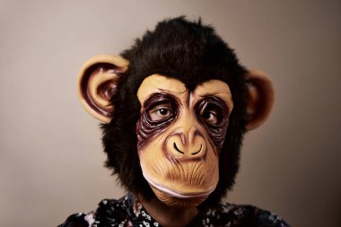 Bej arka planda maymun maskesi takan bir adamın portresi. Retro işlemeli.