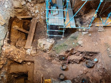 Atapuerca, İspanya - 12 Temmuz 2025: Sierra de Atapuerca 'daki bir kazı çukurunun tepeden görünüşü, arkeologlar için toprak katmanları, ahşap tahtalar ve kovalarla birlikte iskele platformlarını ortaya çıkardı