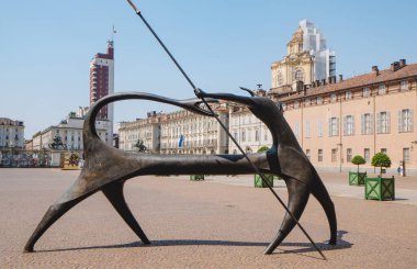 Torin, İtalya - 20 Haziran 2025: Arkaplanda kırmızı Torre Littoria ile birlikte, Piazzetta Reale 'de mızrak tutan büyük bir bronz heykel