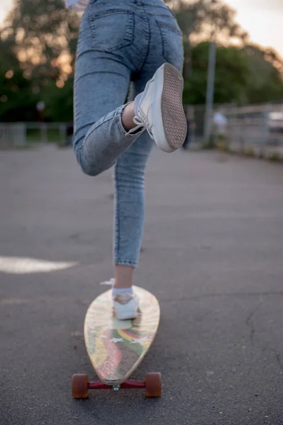 Sporty uliczne: Dziewczyna popycha z nogą i rolkach na longboard. — Zdjęcie stockowe