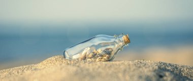 Panoramik yaz kumlu plaj kavramı ile şişe içinde deniz hayvanı kabuğu