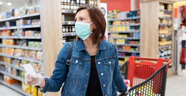 Süpermarketten tıbbi maske alışverişi yapan beyaz kadın manzarası