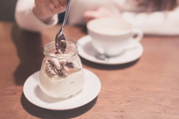 young girl eats dessert and drinks coffee