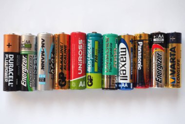 BERLIN, GERMANY - CIRCA MAY 2018: AA batteries of many different brands including GP Duracell Energizer Ansmann Uniross Maxell Panasonic Varta clipart