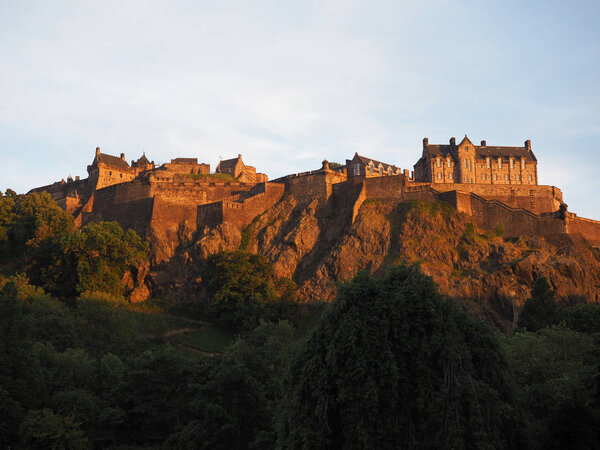 Эдинбургский замок на скале на закате
