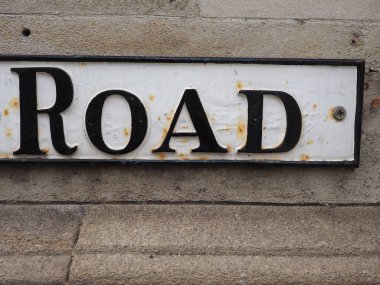 Taştan bir duvarda siyah beyaz yol işareti