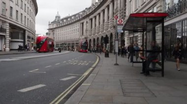 Londra, İngiltere - Yaklaşık Eylül 2019: Regent Street'te kaldırımda yürüyen ve çift katlı otobüsle seyahat eden insanlar