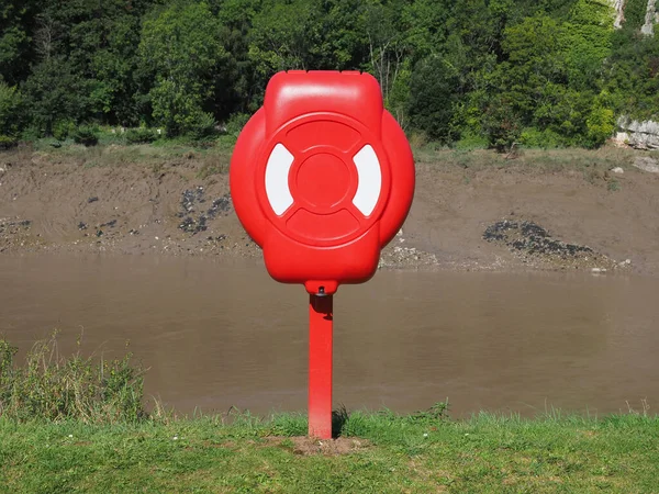 Life buoy on river bank — Stock Photo, Image