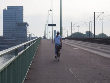 KOELN, GERMANY - CIRCA AĞUSTOS 2019: Şehir merkezinde bisiklet süren kadın
