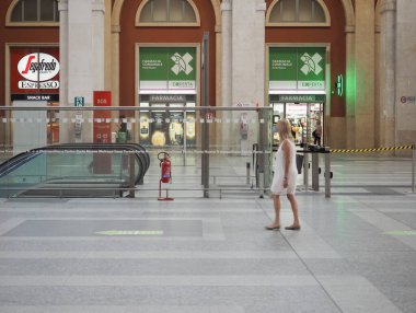 TURIN, İtalya - CRCA HAZİRAN 2020: Torino Porta Nuova tren istasyonu. Beyaz elbiseli yürüyen kadın hareket bulanıklığı gösteriyor.