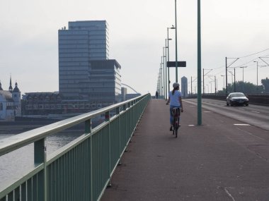 KOELN, GERMANY - CIRCA AĞUSTOS 2019: Şehir merkezinde bisiklet süren kadın