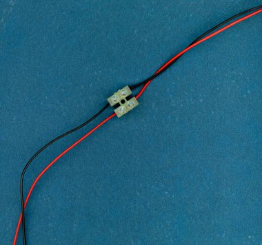 Kırmızı ve siyah elektrik kabloları çift vida terminali ile birleştirilmiştir.