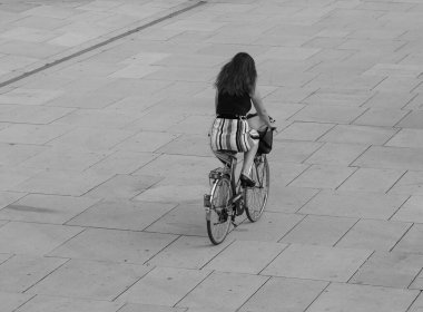 KOELN, GERMANY - CIRCA AĞUSTOS 2019: Şehir merkezinde siyah beyaz bisiklet süren kadın